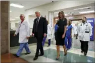  ?? EVAN VUCCI — THE ASSOCIATED PRESS ?? President Donald Trump and first lady Melania Trump walk with surgeon Dr. John Fildes, left, at the University Medical Center after meeting with survivors of the mass shooting Wednesday in Las Vegas.