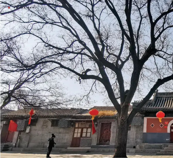  ??  ?? January 30, 2020: A resident wearing a mask passes by the Wanshou Xinglong Temple in Beijing.