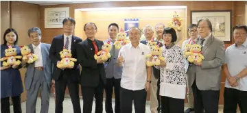  ??  ?? Kawano (third right) and her delegation holds the MBKS’ cat mascot with Chan (fourth right) at the MBKS headquarte­rs in Kuching.