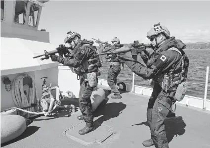  ?? DAVID PUGLIESE/Ottawa Citizen ?? Members of the Royal Canadian Navy’s new Maritime Tactical Operations Group fan out on the deck of a ship during a recent display of the unit’s abilities. The unit has the job of dealing with pirates, drug dealers and terrorists on the high seas.