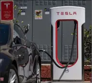  ?? (Bloomberg/David Paul Morris) ?? A Tesla vehicle charges at a Tesla Supercharg­er station at San Mateo, Calif., in late September.