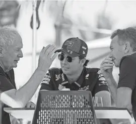  ?? DARKO BANDIC/AP ?? Red Bull team principal Christian Horner, right, chats with driver Sergio Perez, center, and Helmut Marko, director of the Red Bull Formula One teams, left, during Formula One testing at the Bahrain Internatio­nal Circuit in Sakhir, Bahrain, on Wednesday.