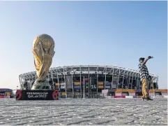  ?? AFP ?? A man takes a selfie in front of a replica of the World Cup trophy outside the Stadium 974 in Doha, one of the venues for Qatar 2022.
