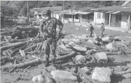  ??  ?? Un soldat colombien dans les décombres causés par une coulée de boue, avant-hier, à Mocoa