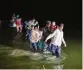  ?? AP ?? Migrants wade through shallow waters toward Roma, Texas, in 2021. A federal judge blocked separation of families to deter immigratio­n.