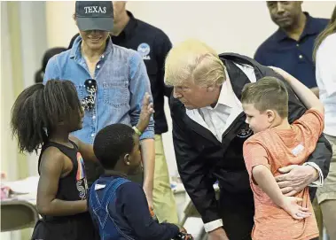  ??  ?? Trump and wife Melania meeting children at an evacuation hall in the NRG Centre, Houston. — AP Taking time to listen: