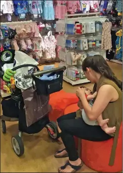  ??  ?? Sitting quietly: Mrs Frangou with baby Elias in Mothercare