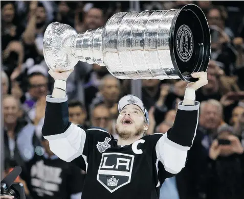 ?? JAE C. HONG/The Associated Press ?? Los Angeles Kings Dustin Brown raises the Stanley Cup. The team played 26 post-season games and has barely three months to get ready for next year.