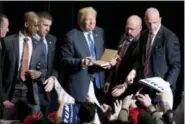  ?? MICHAEL DWYER — THE ASSOCIATED PRESS ?? Republican presidenti­al candidate Donald Trump grins while signing autographs after speaking at a campaign really in Bridgeport, Conn., Saturday.