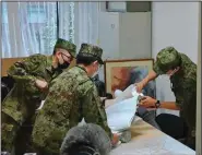  ?? (AP/Kyodo News) ?? Members of Japan's Self-Defense Force work Tuesday at a government office in Sapporo, northern Japan.