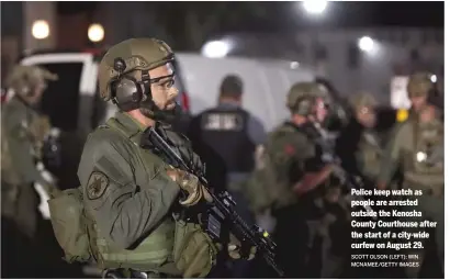  ?? SCOTT OLSON (LEFT); WIN MCNAMEE/GETTY IMAGES ?? Police keep watch as people are arrested outside the Kenosha County Courthouse after the start of a city-wide curfew on August 29.