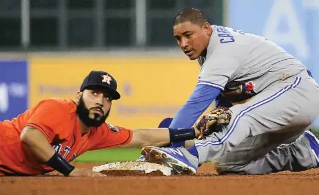  ?? ERIC CHRISTIAN SMITH/THE ASSOCIATED PRESS ?? Astros shortstop Marwin Gonzalez lunges to tag Blue Jays baserunner Ezequiel Carrera, who stole second in the fourth inning of Friday night’s game.