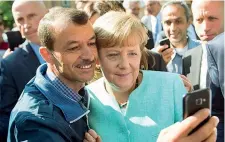  ?? foto: Ansa/Epa) ?? Emozione sul display La cancellier­a tedesca Angela Merkel accetta il selfie di uno dei migranti giunti in Germania dal Medio Oriente (
