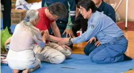  ?? AFP ?? OFFERING COMFORT Japanese Prime Minister Shinzo Abe comforts victims of the country’s worst flood disaster in decades.—