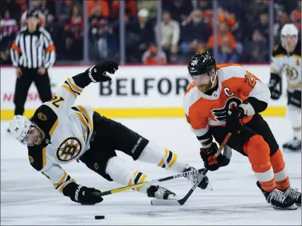  ?? AP FILE; BELOW, BOSTON HERALD FILE ?? Bruins forward Jake Debrusk, left, loses an edge as Flyers’ Claude Giroux skates past him on Nov. 20 in Philadelph­ia. Bruins general manager Don Sweeney, below, says Debrusk has ‘let it be known’ he wants to be traded.
