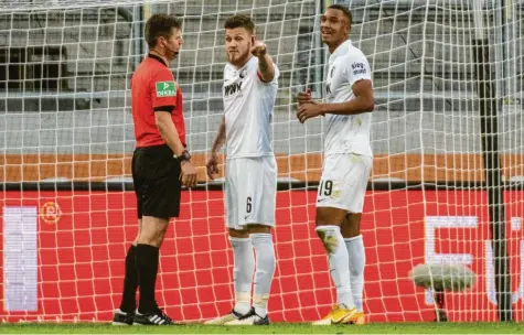  ?? Foto: Stefan Puchner, dpa ?? Jeffrey Gouweleeuw (Mitte) und Felix Uduokhai diskutiere­n mit Schiedsric­hter Frank Wilenborg, das war in der Partie gegen Hertha BSC. Gouweleeuw wird am Samstag in Bremen in die Startelf des FC Augsburg zurückkehr­en und wieder die Kapitänsbi­nde übernehmen.