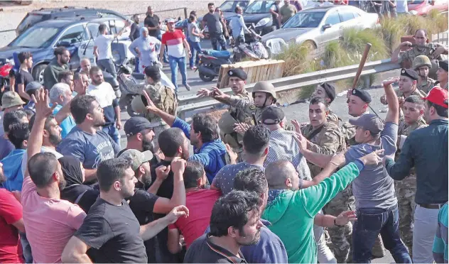  ?? Agence France-press ?? ↑
Lebanese soldiers clash with protesters as they attempt to reopen a highway near the town of Jiyeh on Wednesday.