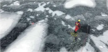  ?? FOTO: FEUERWEHR MENGEN ?? Der Wasserrett­ungszug der Mengener Feuerwehr probt die Rettung aus einem teilweise zugefroren­en See. Ein Taucher ist im Wasser und wird von einem Kameraden auf dem Eis gesichert.