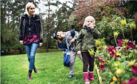  ?? GRÖNA FINGRAR. FOTO: MIKAEL ANDERSSON ?? Karin Melin med barnen Ask och Sonja som gärna är med och planterar blommor.