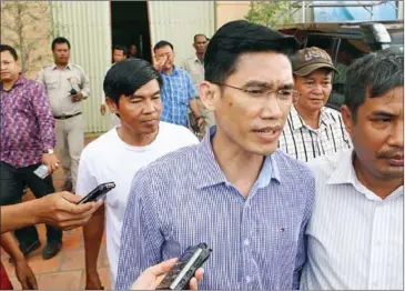  ?? PHA LINA ?? Former RFA reporters Yeang Sothearin (front, in blue shirt) and Oun Chhin (back) escorted by officials after being detained for questionin­g last week in Phnom Penh’s Meanchey district.