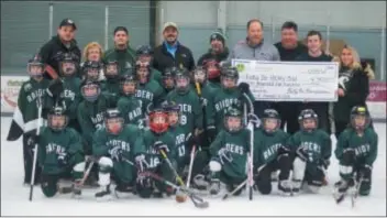  ??  ?? Mike Dolan (back row, fourth from right) accepts a check in support of the Ridley Elementary School ice hockey program from Billy Fox Foundation representa­tives Brian Fox, Bryan Fox, and Courtney Fox. The money is helping more than 20 Ridley elementary school students play hockey.