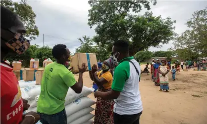  ??  ?? Aid workers distrribut­e food to people displaced by fighting near the besieged town of Palma in northern Mozambique. Photograph: Alfredo Zuniga/AFP