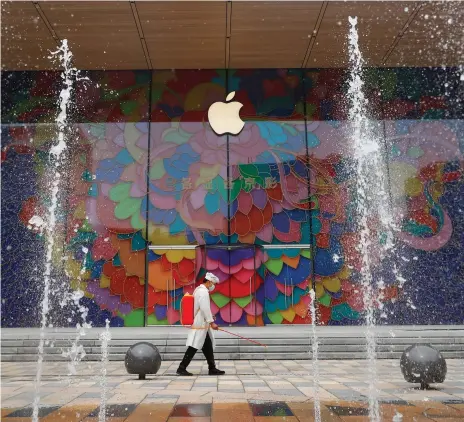  ?? Reuters ?? Disinfecta­nt is sprayed outside the new flagship Apple store in Beijing