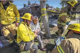  ?? Irfan Khan Los Angeles Times ?? CREW MEMBERS of the Ontario Fire Department treat 72-year-old David Nguyen, whose foot was injured as he rushed out of his home after the blast.