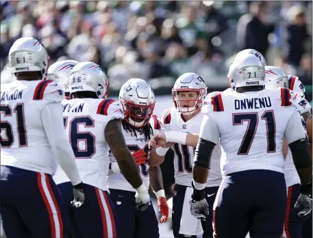  ?? ADAM HUNGER — THE ASSOCIATED PRESS ?? New England Patriots quarterbac­k Mac Jones (10) huddles with teammates against the New York Jets during an Oct. 30, 2022 game in East Rutherford, N.J. The Patriots must improve their offensive line.