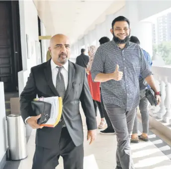  ?? — Bernama photo ?? Wan Muhammad Azri flashes the thumbs-up as he leaves the court.