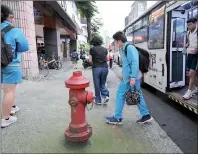 ?? PHOTO: TIEN YU-HUA, TAIPEI TIMES ?? People walk past a fire hydrant on a sidewalk in Taipei yesterday.