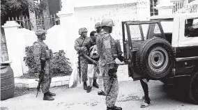  ?? PHOTO BY ADRIAN FRATER ?? Several wanted men were taken into custody yesterday under the public state of emergency now under way in St James.