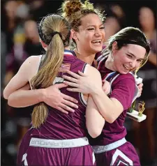  ?? SEAN D. ELLIOT/THE DAY ?? Killingly’s Trinity Angel, center, celebrates her tournament most outstandin­g player award with teammates Emma Carpenter, left, and Sophia Moore after defeating Putnam 54-49 to win the ECC Division II girls’ basketball title on Tuesday night at Mohegan Sun Arena.