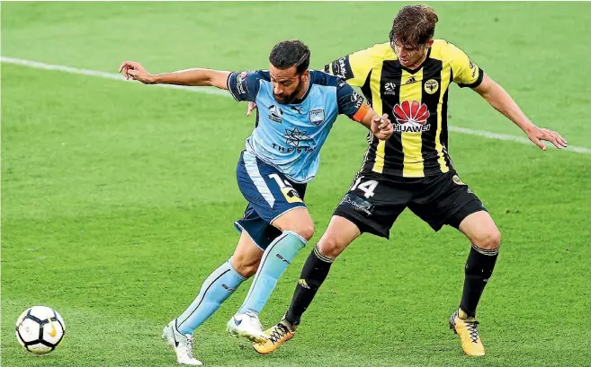  ?? GETTY IMAGES ?? Alex Rufer challenges Sydney FC’s Alex Brosque during the Phoenix’s 4-1 loss to the A-League leaders in Wellington last night.