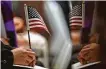  ?? Jon Shapley / Staff file photo ?? A new citizen holds an American flag during a naturaliza­tion ceremony in 2018 at City Hall.