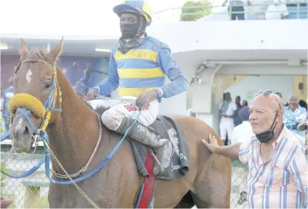  ??  ?? Trainer Vincent Atkinson (right) with his charge Chace The Great with jockey Kiaman Mcgregor in the saddle in the winners’ enclosure.