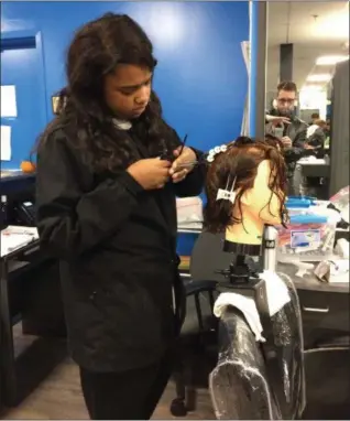  ?? ADAM DODD — THE NEWS-HERALD ?? A student trains on a mannequin head before her client’s appointmen­t at the Mayfield Excel TECC Cosmetolog­y program.