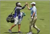  ?? CHUCK BURTON — THE ASSOCIATED PRESS ?? Johnson Wagner, right, is congratula­ted by his caddie after holing out his approach shot on the first hole for an eagle during the third round of the Wyndham Championsh­ip.