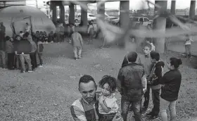  ?? Tamir Kalifa / New York Ttimes ?? People are held by U.S. Customs and Border Protection in an enclosed area beneath the Paso del Norte Internatio­nal Bridge in El Paso recently.