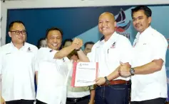  ?? — Bernama photo ?? (From right) Azis witnesses as Loretto receives the Warisan membership forms from Yusof. Looking on at left is Warisan treasurer-general Terrence Siambun.