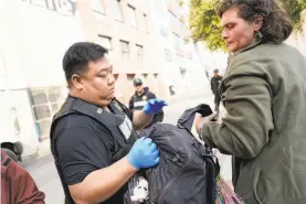  ??  ?? Above: Counselor Elester Hubbard (left) and Mayor London Breed talk with Ebony Holt during a Healthy Streets Interventi­on operation. Left: Deputy Probation Officer Dennis Woo assists Danielle Earls on her way to a counseling program.