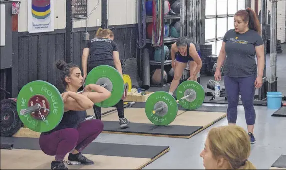  ?? CODY MCEACHERN/TRURO DAILY NEWS ?? During the weightlift­ing worskshop Saturday, Ursula Garza Papandrea kept a watchful eye on the techniques of the women participat­ing, with a focus on lift technique and correction.