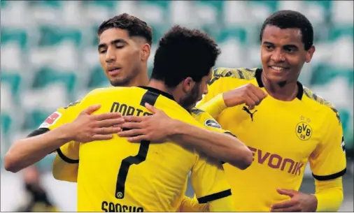  ??  ?? Achraf se abraza con Jadon Sancho tras anotar su gol ante el Wolfsburgo.