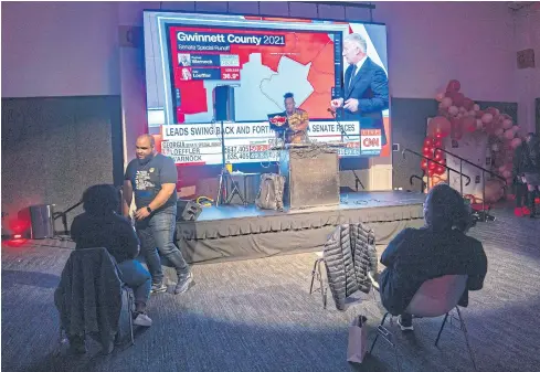  ?? AFP ?? People gather to watch the runoff election tally yesterday in Atlanta, Georgia.