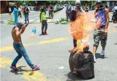  ?? — AFP ?? Anti-government activists demonstrat­e against Venezuelan President Nicolas Maduro at a barricade set up on a road in Caracas.