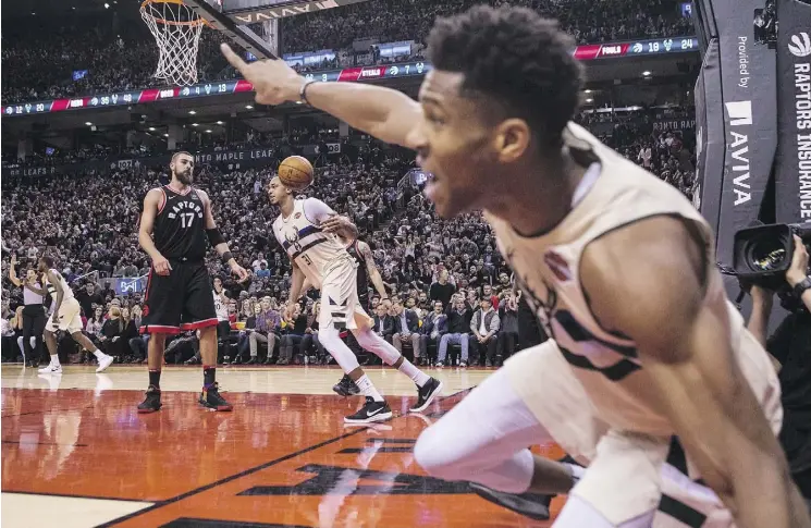  ?? CHRIS YOUNG/THE CANADIAN PRESS ?? Milwaukee Bucks forward Giannis Antetokoun­mpo, right, reacts after Bucks forward John Henson, centre, scores in overtime against the Toronto Raptors on Friday in Toronto. Head coach Dwane Casey says the Raptors have focused on “end-of-game situations”...