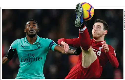  ??  ?? Liverpool’s Andy Robertson clears the ball under pressure from Arsenal’s Ainsley Maitland-Niles on Saturday