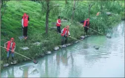  ?? XU YU / XINHUA ?? Workers clean a river in Changxing county, Zhejiang province, in October. The county has invested 7.5 billion yuan ($1.15 billion) in improving its waterways and the aquatic environmen­t over the past three years.