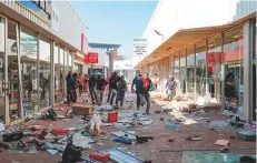  ?? AP ?? People flee from police as they carry goods while looting and vandalisin­g the Lotsoho Mall in Katlehong township.