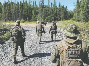  ?? MANITOBA RCMP / HANDOUT VIA REUTERS ?? RCMP officers near Gillam, Man., continue their search for Kam Mcleod and Bryer Schmegelsk­y, teenage fugitives wanted in the murders of three people, on Monday. The police have searched thousands of kilometres of wilderness.